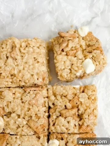 cinnamon toast crunch marshmallow treats cut into squares with one being pulled.
