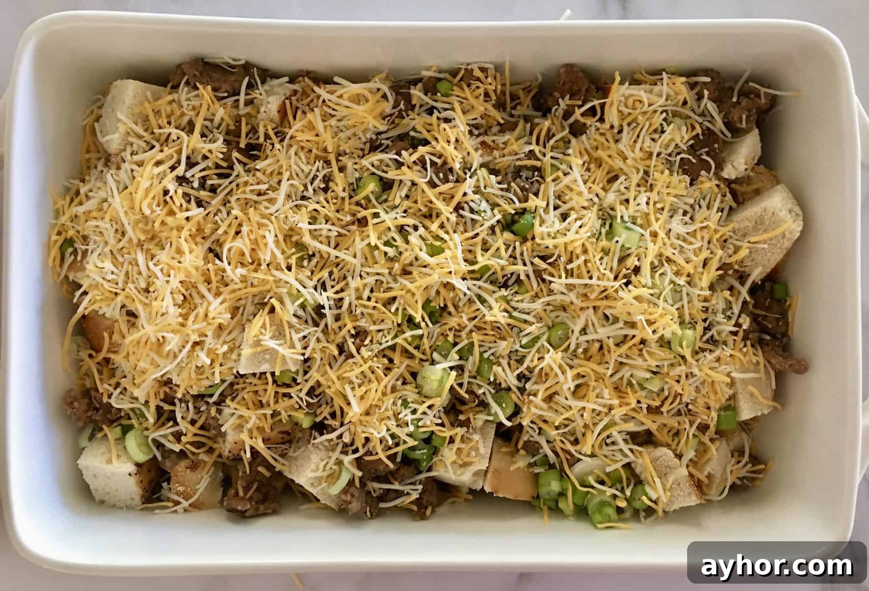 Everything Bagel Sausage Breakfast Bake 5 Breakfast Casserole filled with bread, meat, green onions, and cheddar cheese.